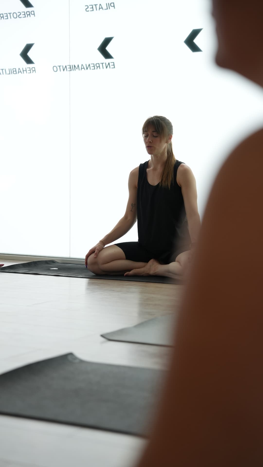 Instructora guiando una práctica de meditación en el centro FisioFit